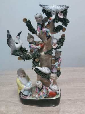 A large chinese statue with children climbing a tree