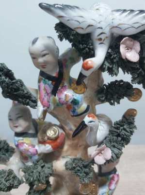 A large chinese statue with children climbing a tree